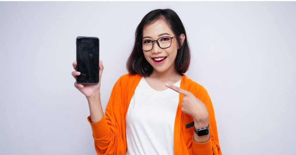 A happy person using a budgeting app on their smartphone, reflecting the effectiveness of the Top Budgeting Tools for 2025.