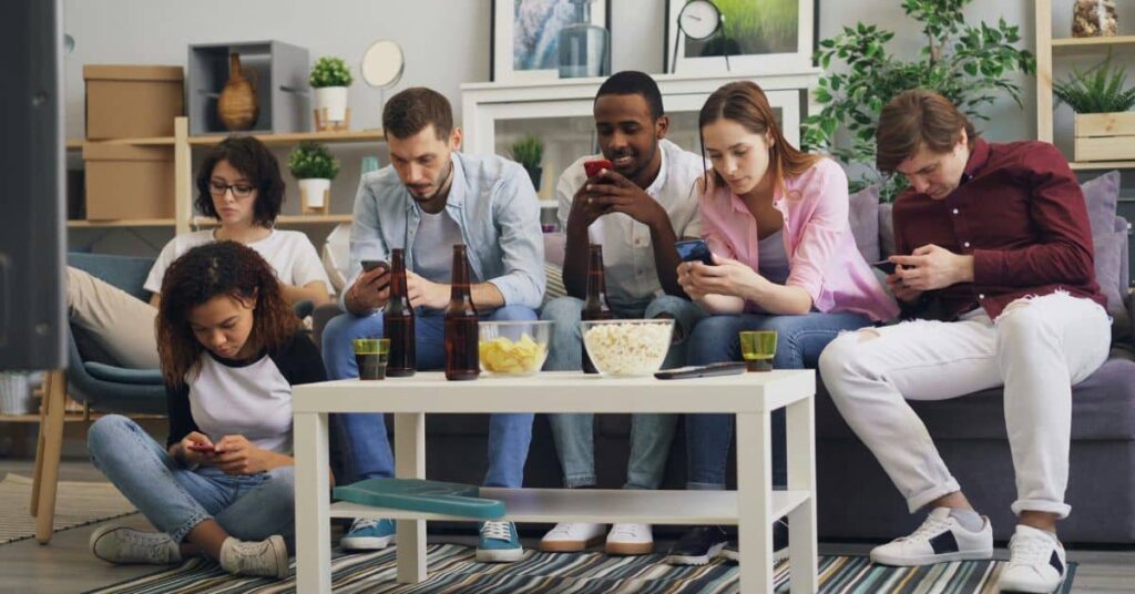 A group of young people using smartphones to manage finances, showcasing the popularity of the Top Budgeting Tools for 2025.