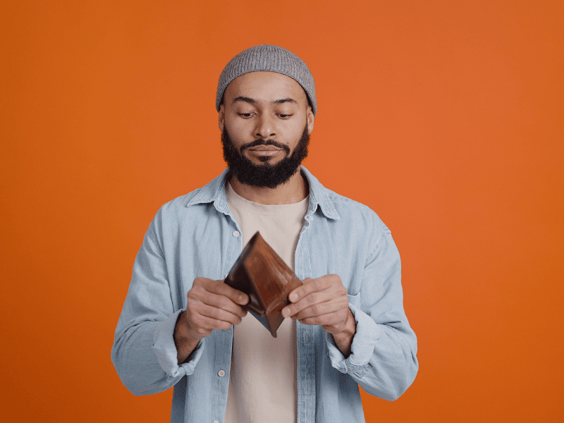 young man holding empty wallet showing impact of Gen Z financial advice on daily choices